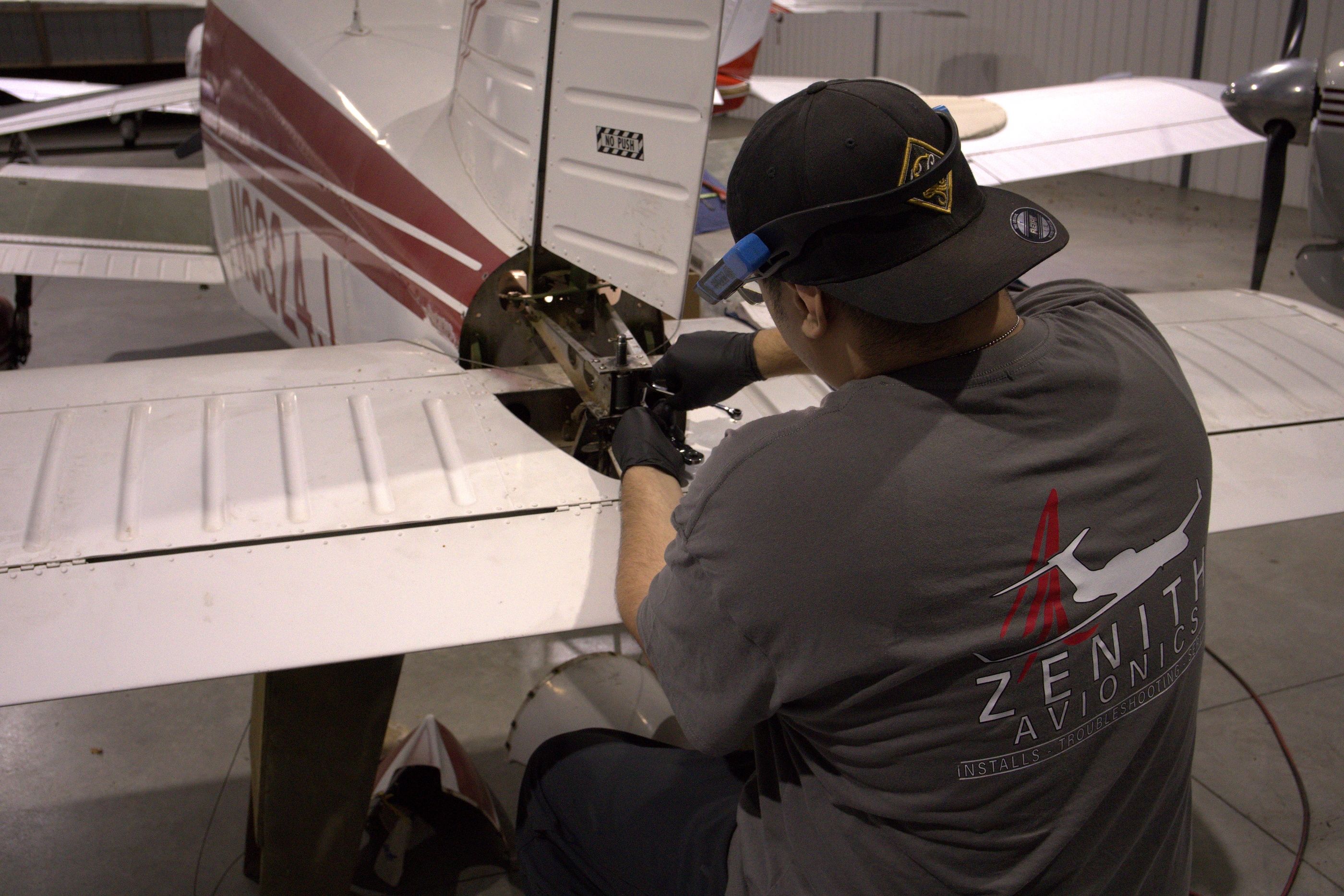 Zenith Avionics technician working on an aircraft in the hangar